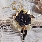 Pendentif Attrapes R&ecirc;ves brod&eacute; avec des fleurs Lucites Noires sur une dentelle Beige et une estampe dor&eacute;e. Les pendants sont des fleurs en cristal avec des rocailles. Mont&eacute; avec une cha&icirc;ne plaqu&eacute; Or